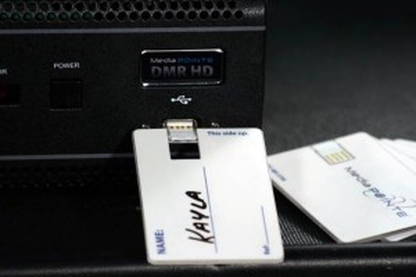 A named MediaPOINTE KeyCard being inserted into the USB port of a DMR HD