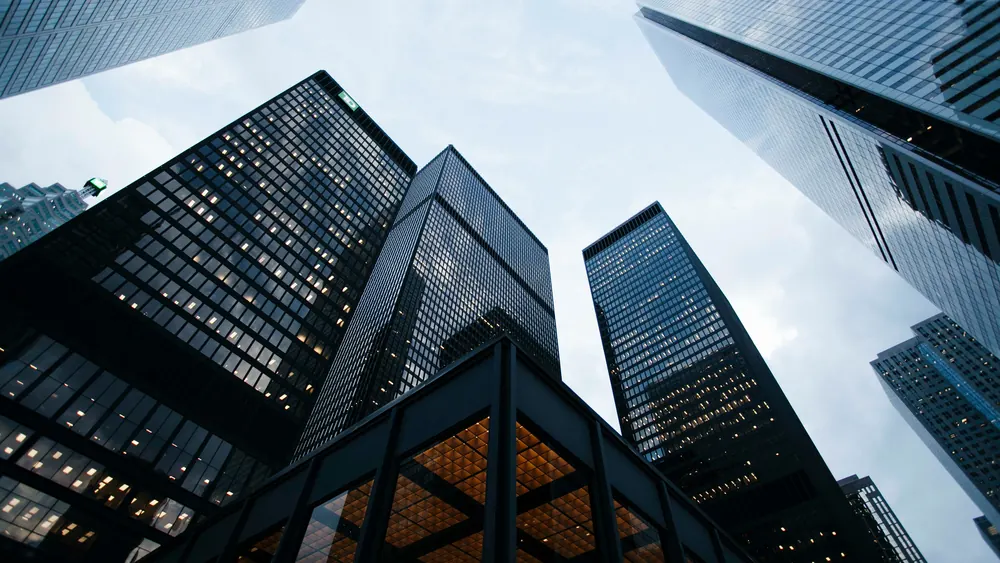 Downtown towers seen from street level, glass facades converging on the sky